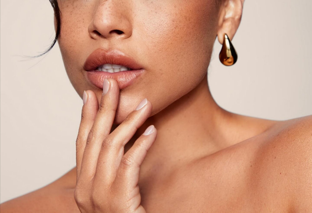 Close-up of lips and lower face highlighting smooth skin and volume, representing results from Sculptra and hyaluronic acid filler treatments